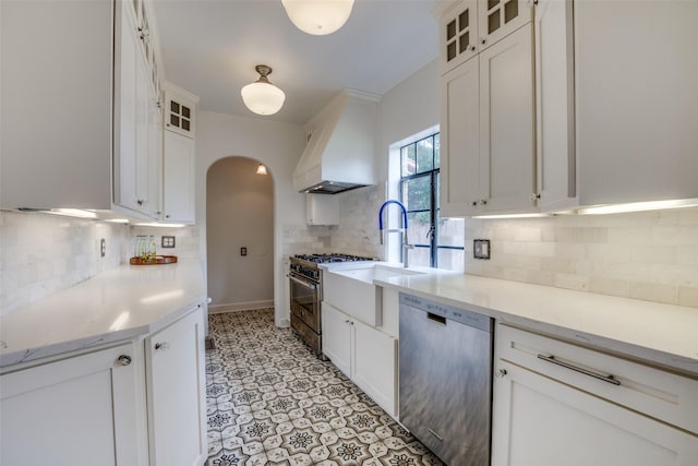 kitchen featuring light stone counters, appliances with stainless steel finishes, custom exhaust hood, and white cabinets