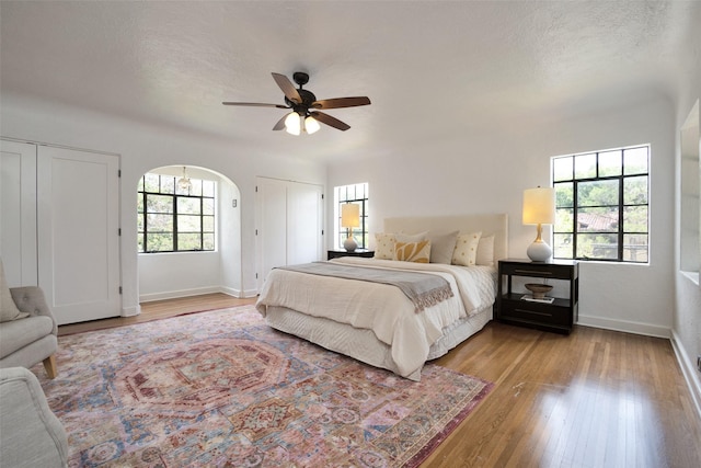 bedroom with a textured ceiling, light hardwood / wood-style floors, and ceiling fan