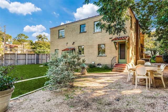 rear view of house featuring a lawn