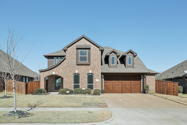 view of front of house featuring fence, concrete driveway, and brick siding