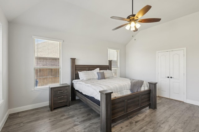 bedroom featuring a ceiling fan, vaulted ceiling, baseboards, and wood finished floors