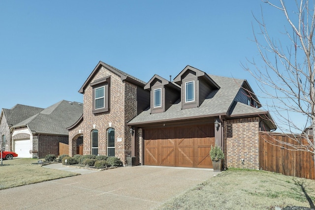 view of front of home featuring a garage, concrete driveway, fence, a front lawn, and brick siding