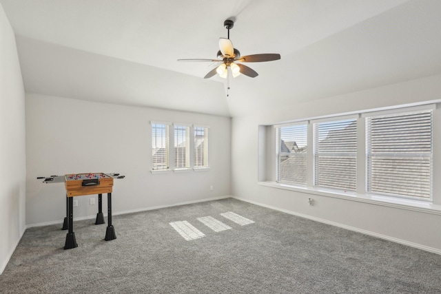 carpeted spare room with lofted ceiling, a ceiling fan, and baseboards