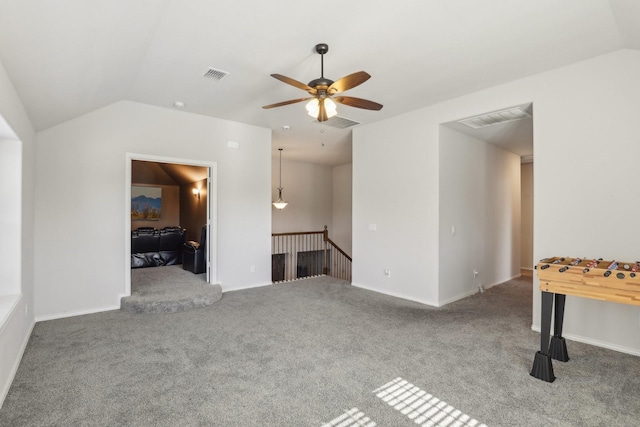 interior space featuring lofted ceiling, baseboards, visible vents, and a ceiling fan