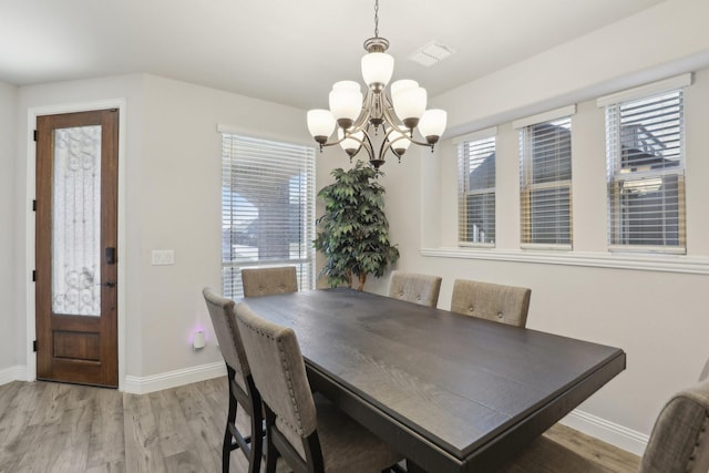 dining area with visible vents, a notable chandelier, light wood-style flooring, and baseboards