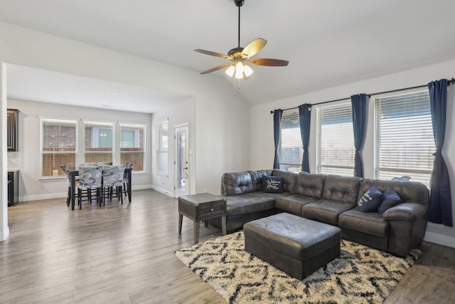 living room with vaulted ceiling, ceiling fan, wood finished floors, and baseboards