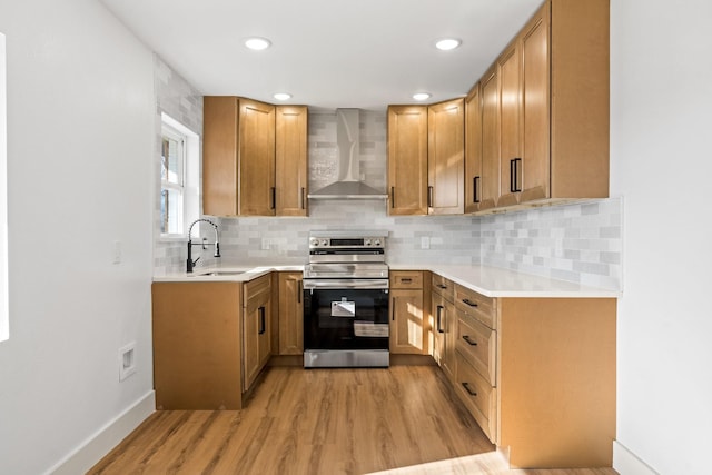 kitchen featuring sink, light hardwood / wood-style flooring, tasteful backsplash, stainless steel electric stove, and wall chimney exhaust hood