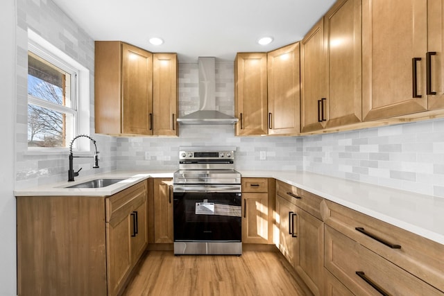 kitchen featuring sink, stainless steel range with electric cooktop, light hardwood / wood-style flooring, wall chimney range hood, and backsplash