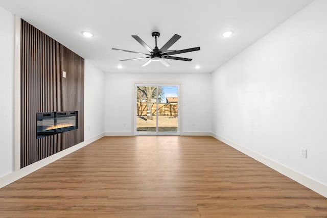 spare room with ceiling fan and light wood-type flooring