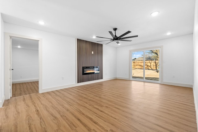 unfurnished living room featuring ceiling fan, a fireplace, and light hardwood / wood-style floors