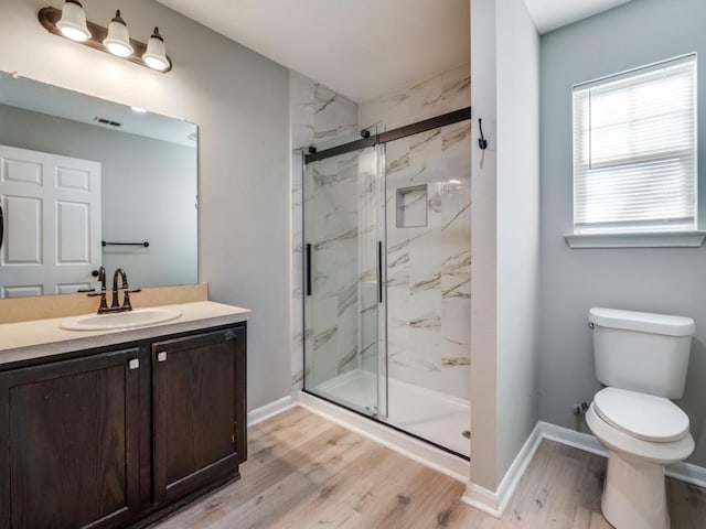 bathroom with hardwood / wood-style flooring, vanity, toilet, and walk in shower