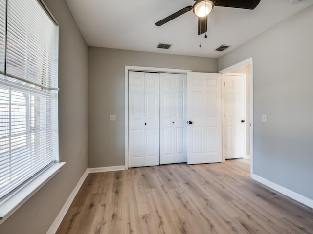 unfurnished bedroom featuring light hardwood / wood-style flooring, ceiling fan, and a closet