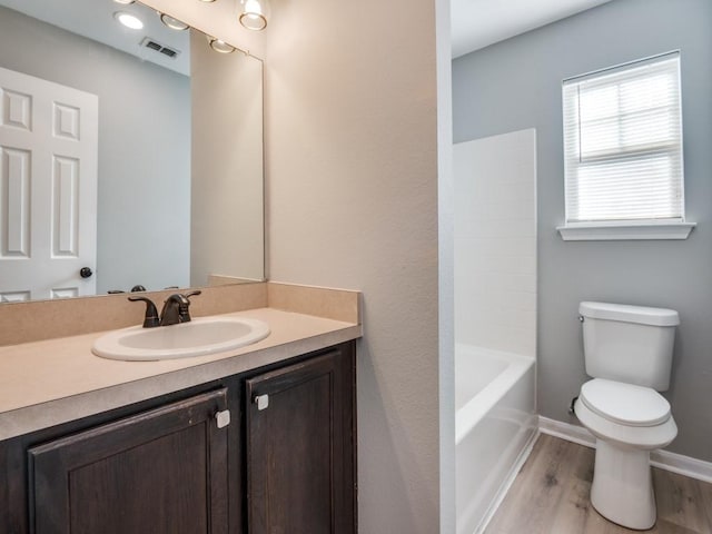 full bathroom with vanity, toilet, hardwood / wood-style floors, and shower / bathing tub combination