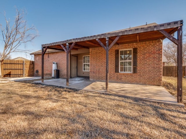 rear view of property with a lawn and a patio