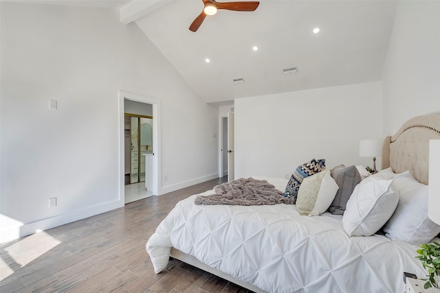 bedroom with ceiling fan, wood-type flooring, ensuite bath, and vaulted ceiling with beams