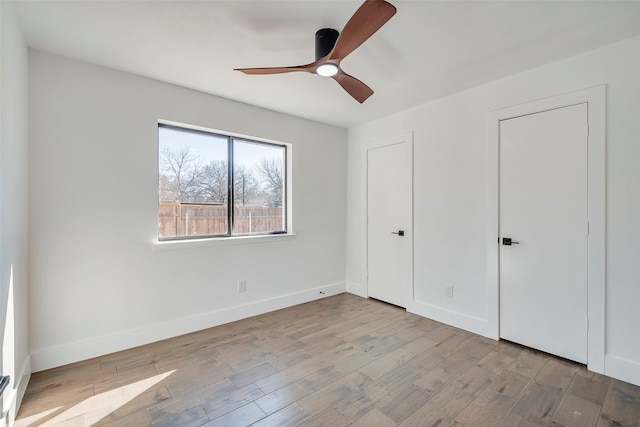 unfurnished bedroom with ceiling fan and light hardwood / wood-style flooring