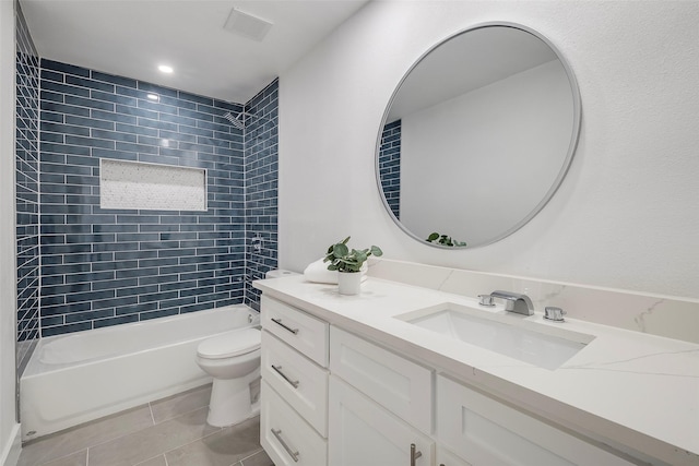 full bathroom featuring tiled shower / bath combo, vanity, tile patterned floors, and toilet