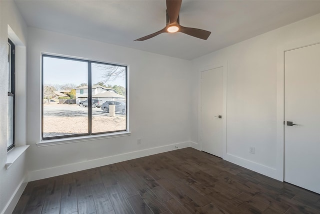 empty room with dark hardwood / wood-style floors and ceiling fan