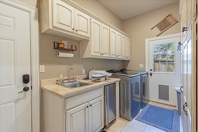 laundry room featuring cabinets, separate washer and dryer, sink, and light tile patterned floors