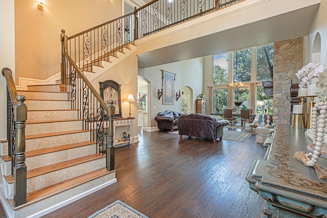 staircase featuring wood-type flooring and a towering ceiling