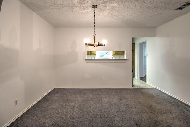 unfurnished dining area featuring carpet floors, a textured ceiling, and a chandelier