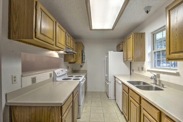 kitchen featuring white appliances, sink, a textured ceiling, and light tile patterned floors