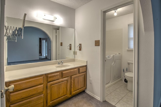 bathroom featuring tile patterned floors, vanity, toilet, and a textured ceiling