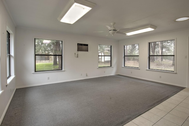 empty room featuring a wall mounted air conditioner, ornamental molding, tile patterned floors, and ceiling fan