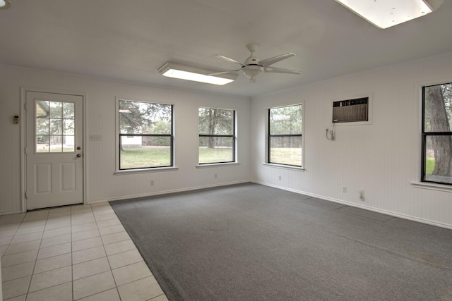 tiled empty room featuring crown molding, a wall mounted air conditioner, and ceiling fan