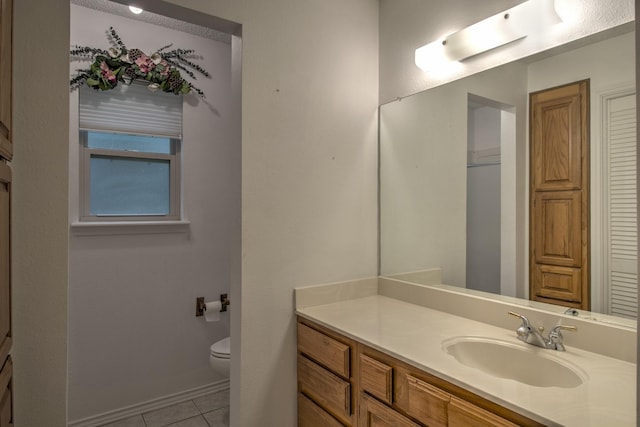 bathroom with tile patterned flooring, vanity, and toilet