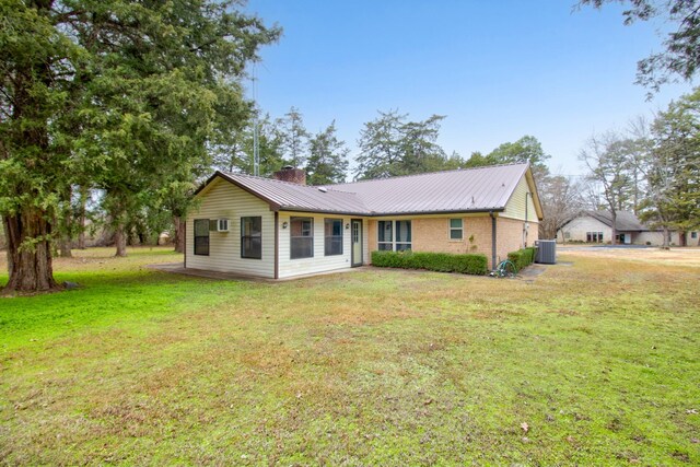 rear view of property with a yard and central AC