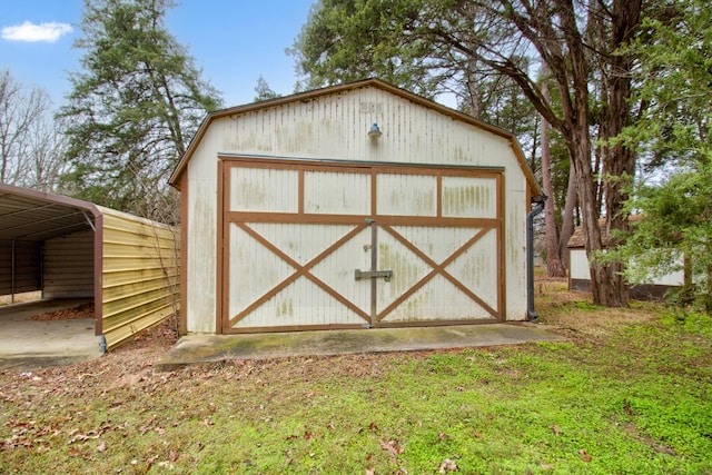 view of outdoor structure with a carport and a yard