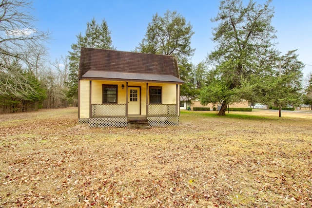 exterior space with covered porch and a front lawn