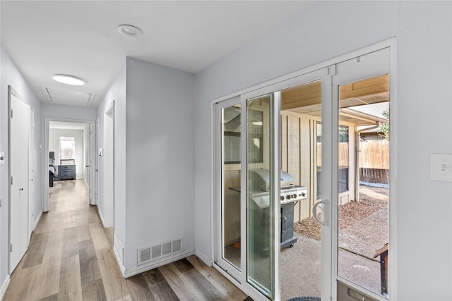 hallway with plenty of natural light and light hardwood / wood-style flooring