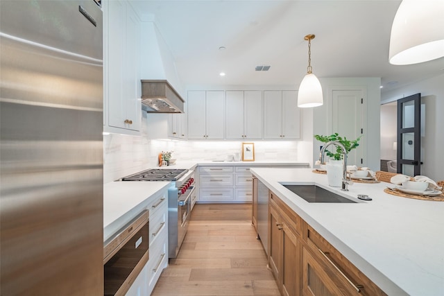 kitchen featuring white cabinetry, sink, pendant lighting, and appliances with stainless steel finishes