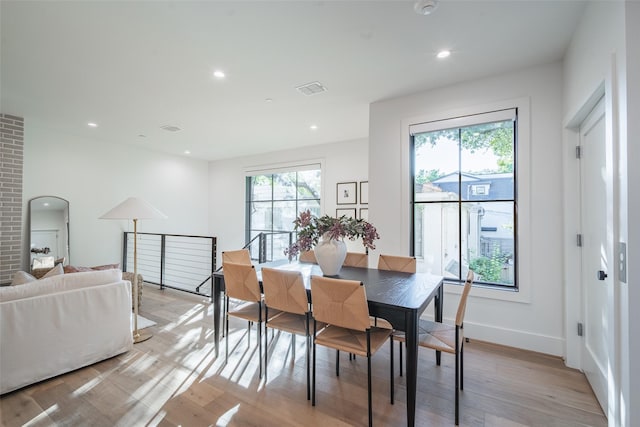 dining space featuring plenty of natural light and light hardwood / wood-style flooring