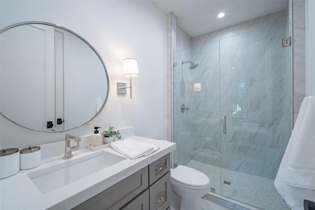 bathroom featuring vanity, toilet, and a shower with shower door