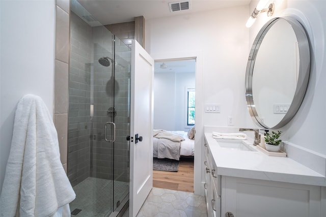 bathroom with tile patterned flooring, vanity, and walk in shower