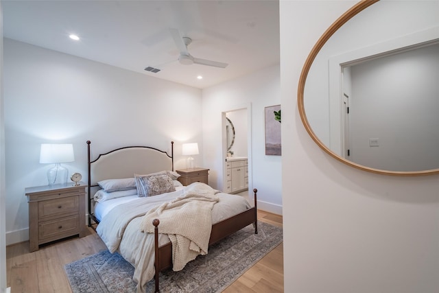 bedroom with ceiling fan, ensuite bathroom, and light wood-type flooring