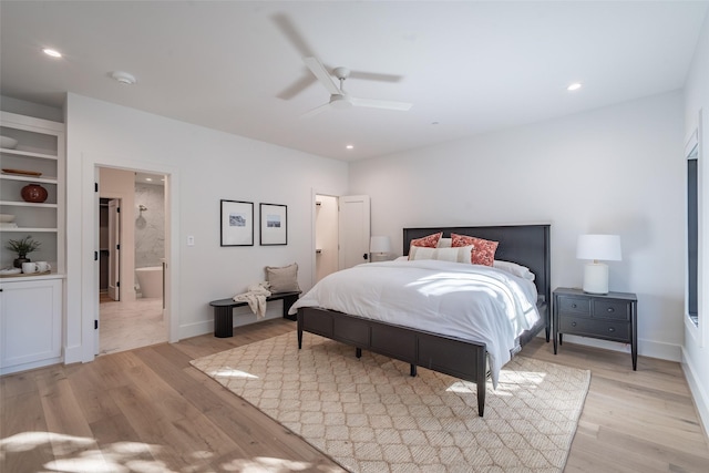 bedroom with light hardwood / wood-style flooring, ceiling fan, and ensuite bath