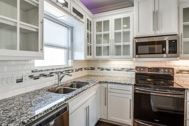 kitchen with tasteful backsplash, white cabinetry, appliances with stainless steel finishes, and sink