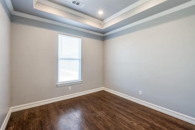 spare room with crown molding, a tray ceiling, and hardwood / wood-style floors