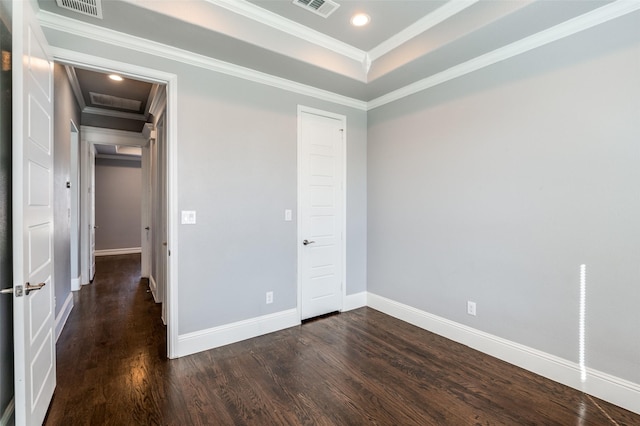 unfurnished bedroom featuring ornamental molding, dark hardwood / wood-style floors, and a tray ceiling