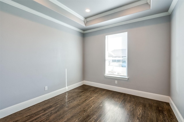 unfurnished room featuring crown molding, dark wood-type flooring, and a raised ceiling