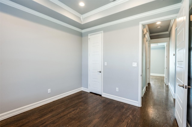 spare room with dark hardwood / wood-style flooring, ornamental molding, and a raised ceiling