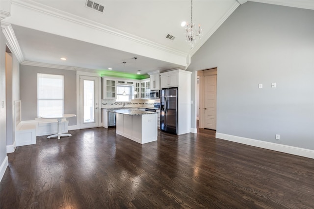 kitchen featuring a kitchen island, pendant lighting, white cabinets, dark stone counters, and stainless steel appliances