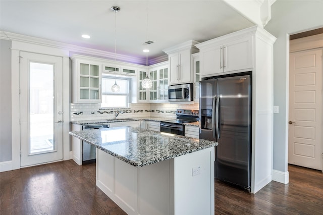 kitchen featuring a kitchen island, appliances with stainless steel finishes, sink, white cabinets, and hanging light fixtures