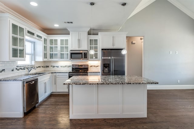 kitchen featuring sink, white cabinetry, stainless steel appliances, light stone counters, and a kitchen island