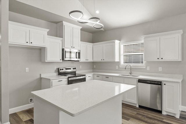 kitchen with stainless steel appliances, white cabinetry, a center island, and sink