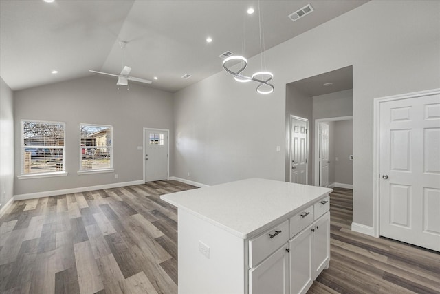 kitchen featuring hanging light fixtures, hardwood / wood-style flooring, a center island, and white cabinets